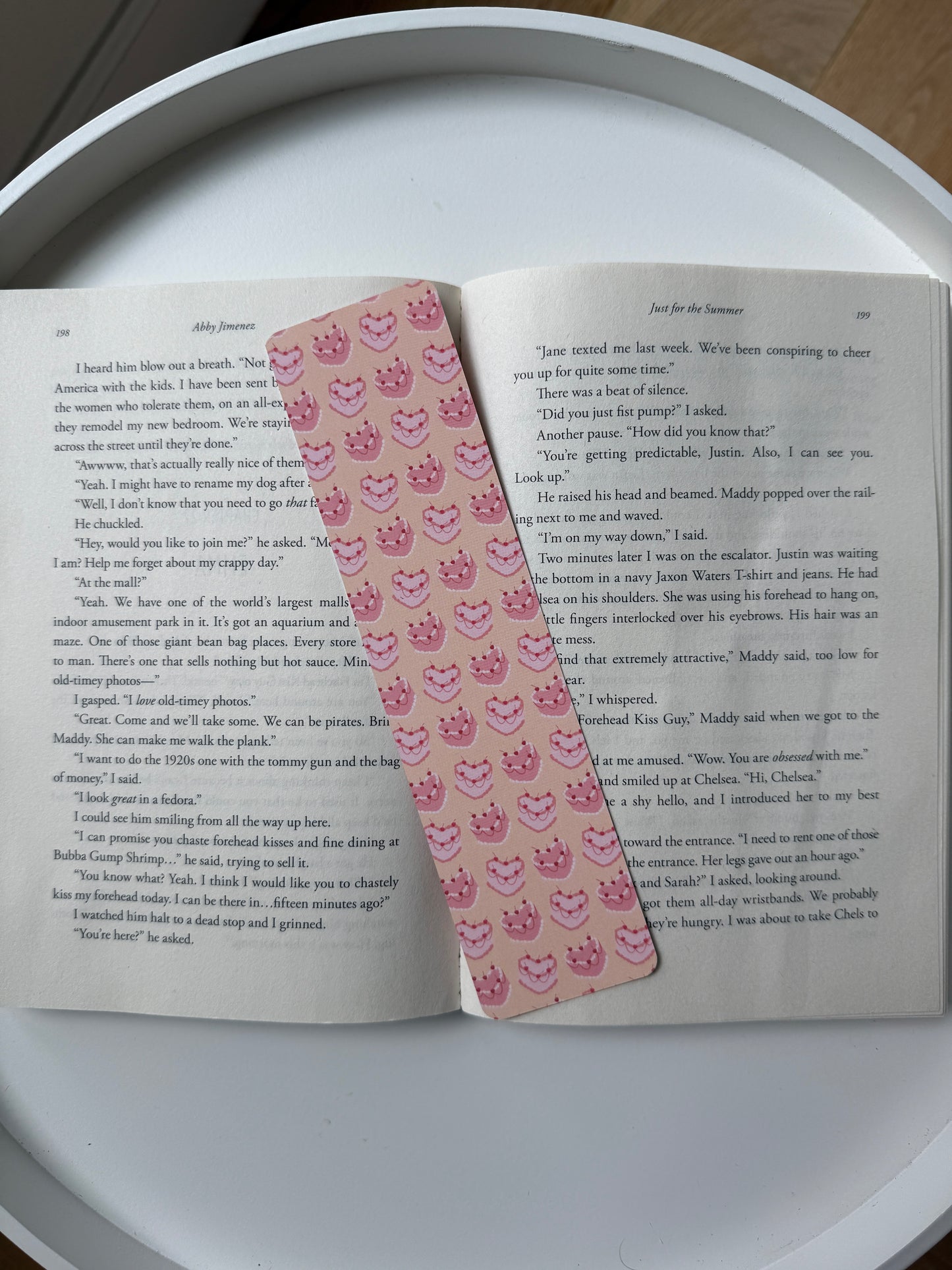 Open book with a pink decorative bookmark on a white surface