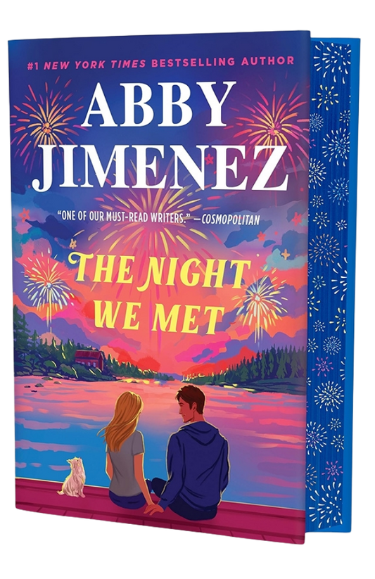Book cover of 'The Night We Met' by Abby Jimenez with a couple and dog on a dock at sunset.