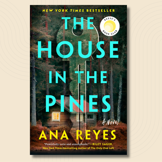Book cover for the novel 'The House in the Pines' by Ana Reyes, featuring a rustic cabin in a pine forest with large turquoise title text and a Reese's Book Club badge, shown on a light beige background.