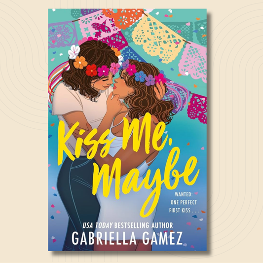 Book cover for 'Kiss Me, Maybe' by Gabriella Gamez, featuring an illustrated scene of two women about to kiss under colorful papel picado banners. The title is written in large yellow script, with the author's name in white at the bottom.
