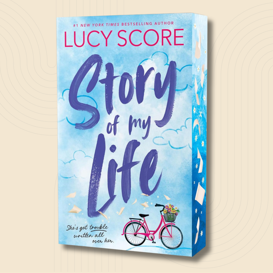 Book cover for 'Story of My Life' by Lucy Score, featuring a light blue watercolor sky with clouds, large purple handwritten title text, a pink bicycle with flowers, and the author's name in pink at the top. The book is shown standing upright against a warm beige background with subtle concentric circle patterns.
