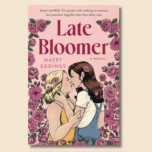 Book cover for the novel 'Late Bloomer' by Mazey Eddings, featuring a pink background with a border of pink roses and an illustration of two young women embracing and kissing.