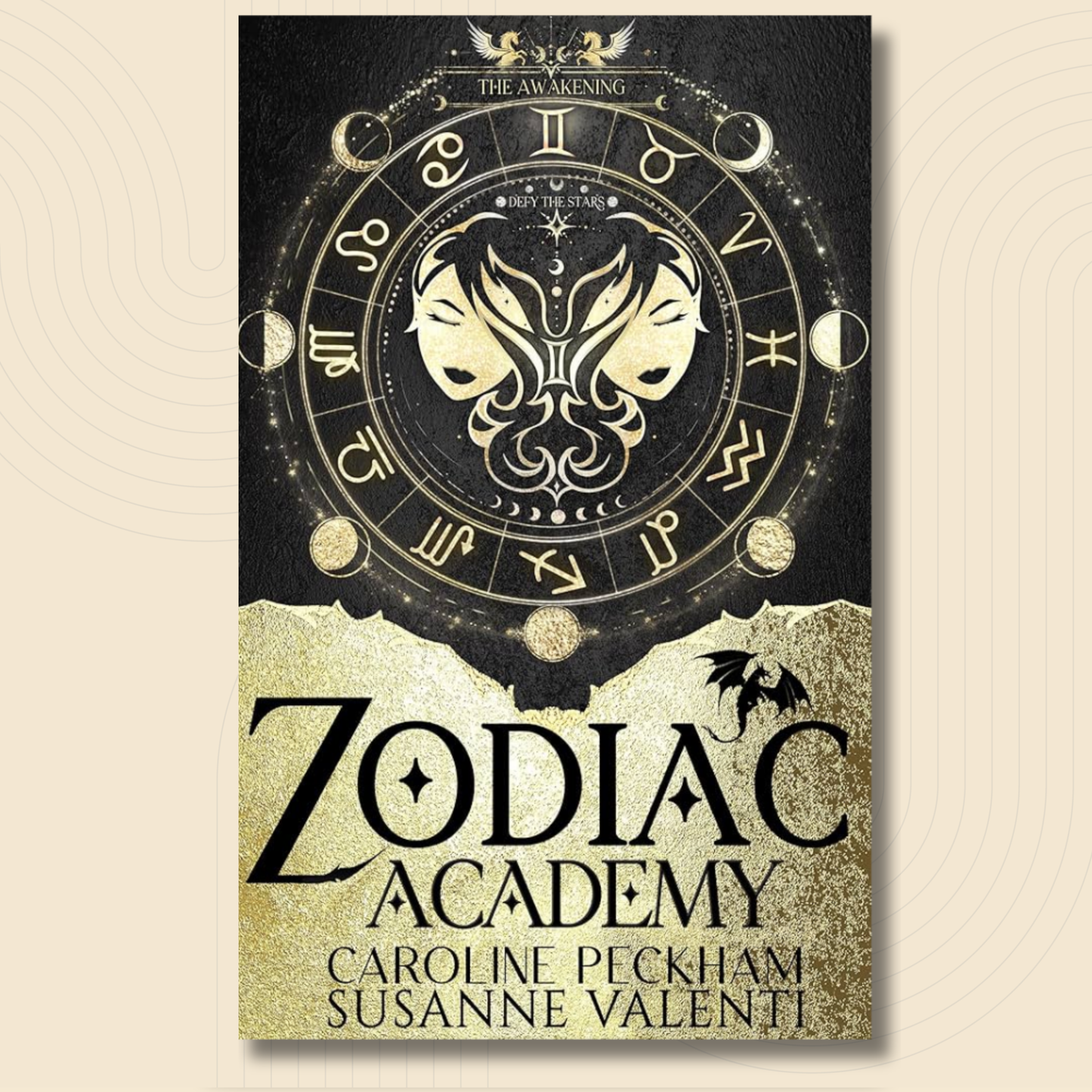 A book cover for 'Zodiac Academy' by Caroline Peckham and Susanne Valenti, featuring a black and gold design with a zodiac wheel, twin faces, and a bat silhouette.