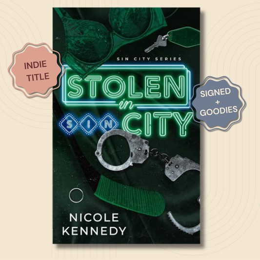 Book cover for 'Stolen in Sin City' by Nicole Kennedy, featuring a dark green and black background with neon green title text, handcuffs, a green hat, and a key. Two badge overlays on the sides read 'INDIE TITLE' and 'SIGNED + GOODIES'.