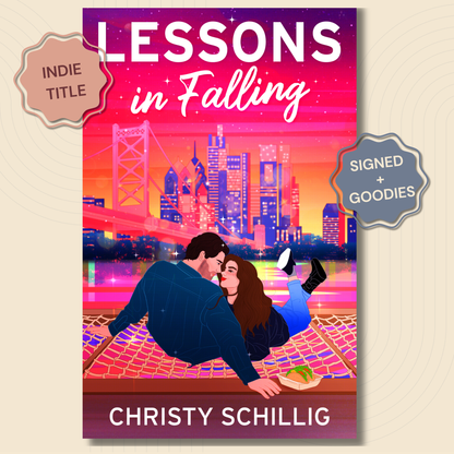 Book cover for 'Lessons in Falling' by Christy Schillig, featuring a colorful illustration of a couple on a hammock in front of a city skyline at sunset. Two badges on the sides read 'Indie Title' and 'Signed + Goodies'.